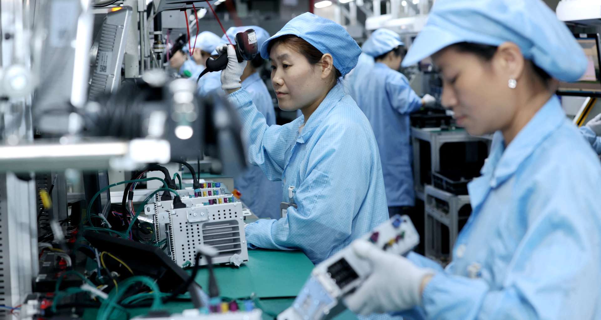 工作人員在電子設備生產線作業的資料照，作為製造業示意，非本次統計調查現場。